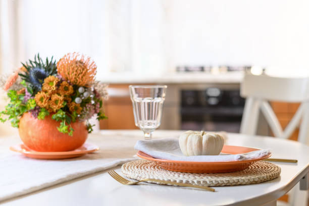 istock Thanksgiving day table setting decorated fall flowers, pumpkins in kitchen interior. 1434779857