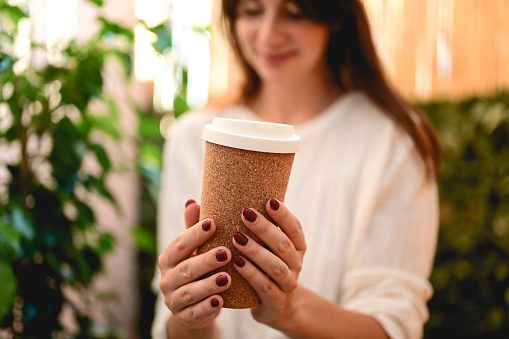 Female hand with paper cup of coffee take away.