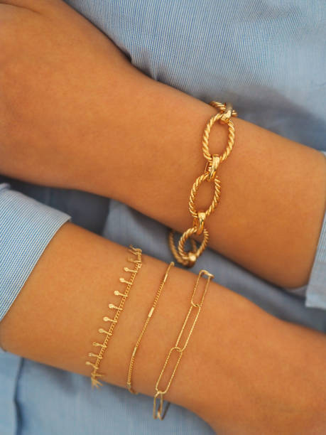 Gold bracelets accumulation on a woman wrist stock photo