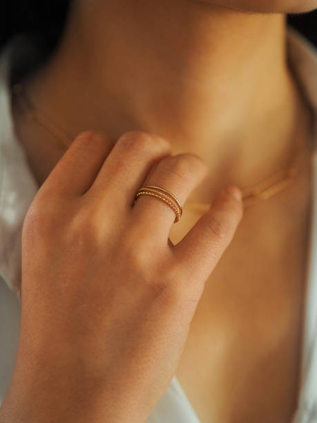 bague en or sur une main de femme - necklace chain gold jewelry photos et images de collection