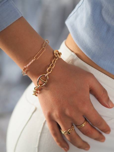 Gold bracelets accumulation on a woman wrist stock photo