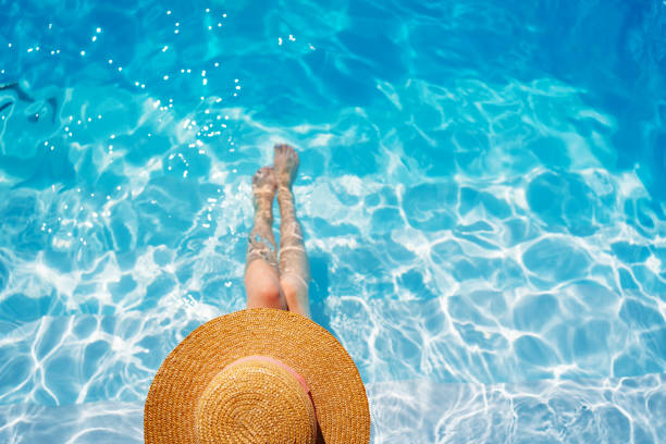istock top view. a woman in a straw hat in the pool. 1434781815