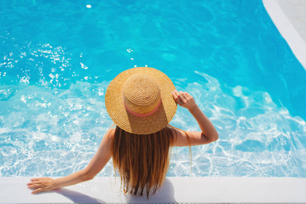 istock top view. a woman in a straw hat in the pool. 1434781920