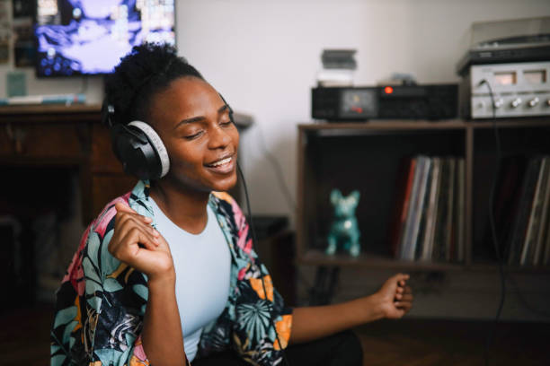 young woman listening to music at home stock photo