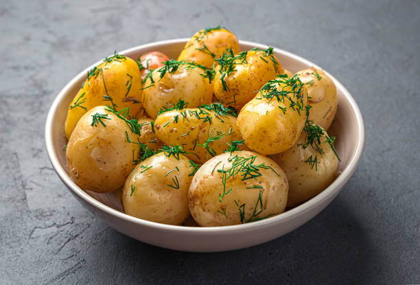 istock Boiled potatoes with dill and butter close-up on a dark background. 1434788534