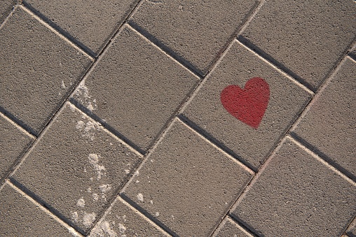 A red heart drawn on road bricks