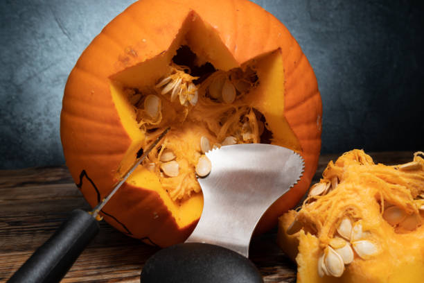 istock Cleaning out Halloween pumpkin for carving, removing guts from inside. 1434790837