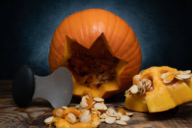 istock Cleaning out Halloween pumpkin for carving, removing guts from inside. 1434790889