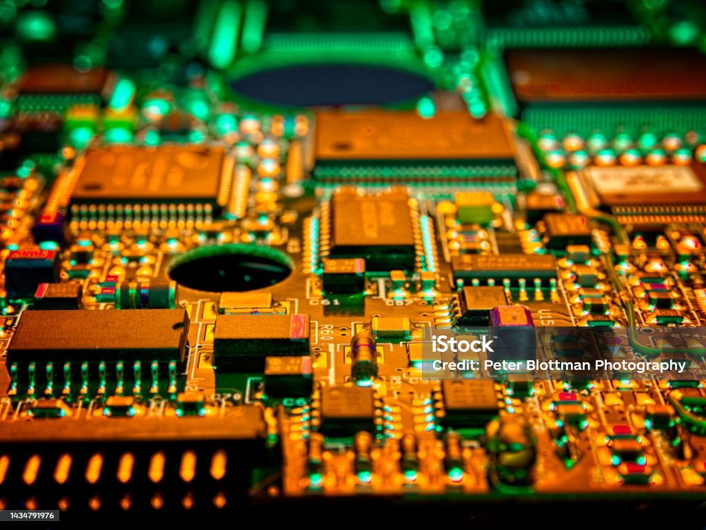 High-tech computer board with chips used for rapid calculations High-tech computer board with chips used for rapid calculations. Illuminated with green and gold lighting as a concept for making money with calculations and mining crypto currencies such as Bitcoin. Computer Chip Stock Photo