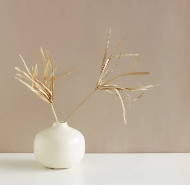 istock Dry grass branches in a vase standing on a beige  wall with copy space. Minimalistic stylish home decor concept.Boho style. 1434792092