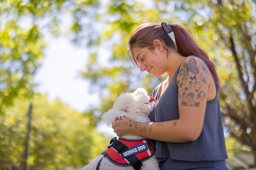 A woman with her service dog at the park.