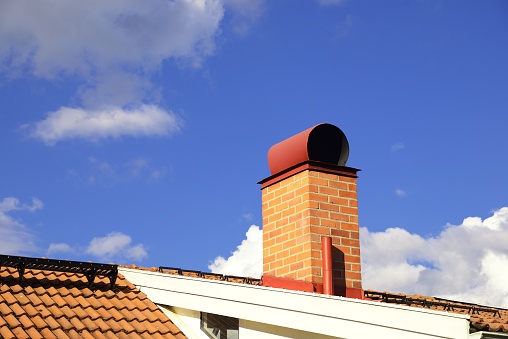 Smoke stack on the tiled roof of a family house