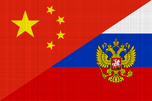 Contact between Russia and the People's Republic of China. Concept. Russia and China flag background on fabric texture.
