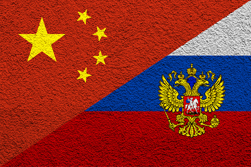 Contact between Russia and the People's Republic of China. Concept. Russia and China flag background on cement wall texture.