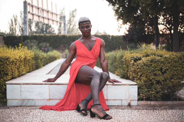 A young androgynous African boy posing in the middle of a park.