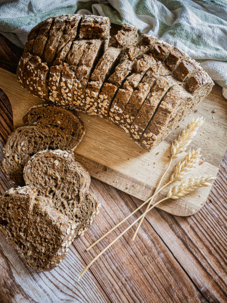istock Slices of fresh bread and ears of corn on a rustic table 1434804728