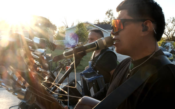 Young chicano hispanic man singing performing in a latino band outdoors concert