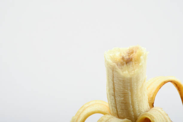 Peeled and bitten banana on the white background with copy space