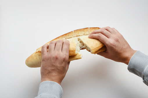 Breaking bread, hand holding bread and breaking bread on the white background