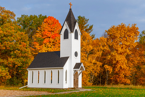 Autumn colorful trees surround little country chapel. This is not a real church, it is very small, but very scenic.