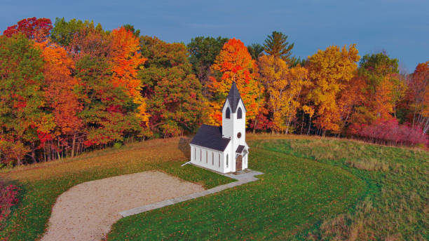 Autumn colorful trees surround little country chapel. This is not a real church, it is very small, but very scenic.