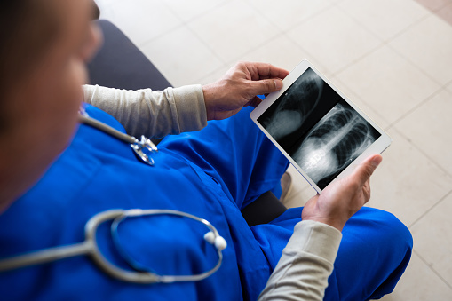 Doctor looking at his patients X-ray image on digital tablet