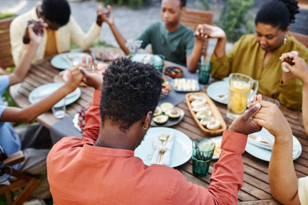 Black Family Praying Together at Dinner Outdoors
