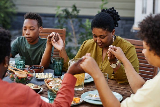 夕食時にグレースを言う家族 - praying saying grace dinner meal ストックフォトと画像