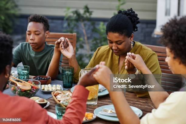 Family Saying Grace at Dinner