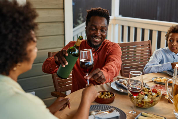 istock Man Pouring Wine at Dinner Table Outdoors 1434816547