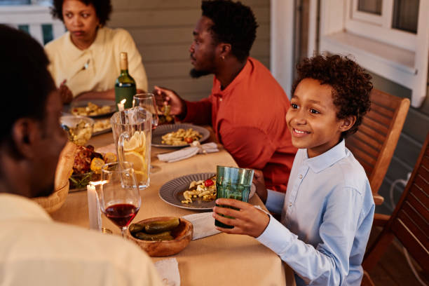 jovem negro curtindo jantar com a família - family thanksgiving dinner praying - fotografias e filmes do acervo