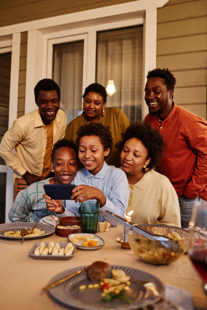 Happy Family Taking Selfie Photo at Dinner Vertical portrait of happy African American family taking selfie photo at house terrace in evening huge black woman pictures stock pictures, royalty-free photos & images