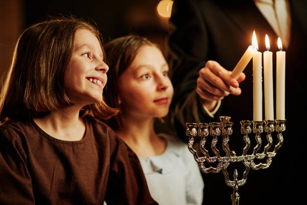 istock Smiling Girls Looking at Menorah Candle 1434820335