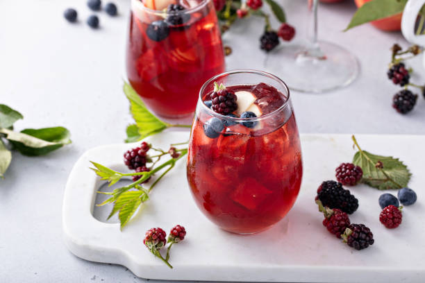 herbstbeeren-apfel-sangria in einem glas mit eis - raspberry table wood autumn stock-fotos und bilder