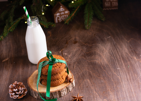 Cookies and milk for Santa Clause on wood background, copy space