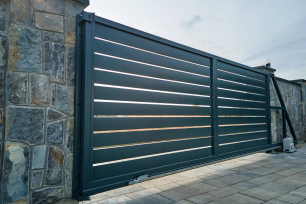 istock Wide automatic sliding gate with remote control installed in high stone fense wall. Security and protection concept 1434825059