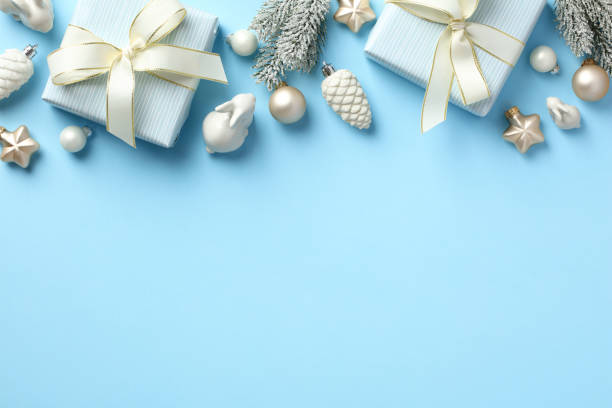 istock Christmas frame top border with gift boxes, baubles, decorations, fir tree branches on pastel blue background. Flat lay, top view, copy space. 1434827911