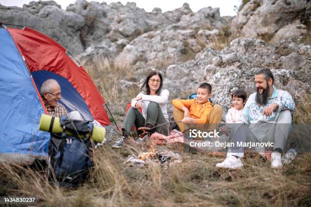 Family Enjoying In Nature Preparing Sausage On Campfire Stock Photo - Download Image Now