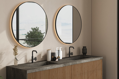 Marble basin standing on a wooden bathroom furniture. Double oval mirrors are hanging on a beige wall. A close up. Front view. 3d rendering