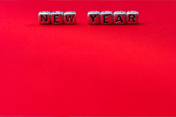 the phrase new year is written in multicolored letters on a red background. Creative concept for new year greeting card. High quality photo