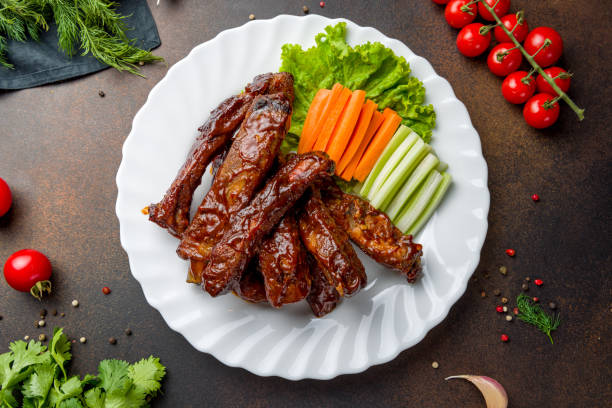 istock Barbecue pork ribs on white plate top view on dark brown table 1434836778