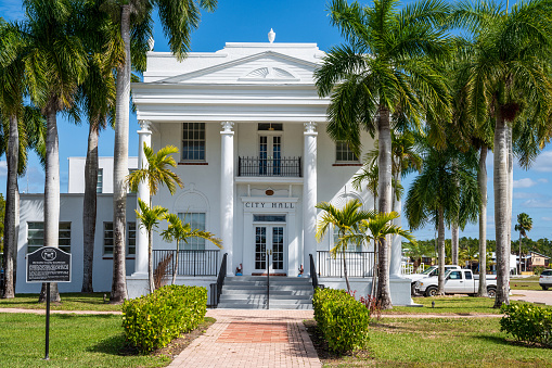 Everglades City, FL, USA - January 30, 2020: Facade of Everglades City Hall surrounded by palm trees on a sunny day