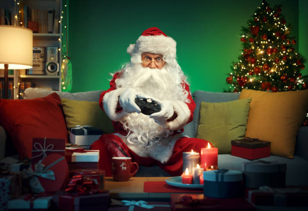 Happy Santa Claus playing video games at home stock photo