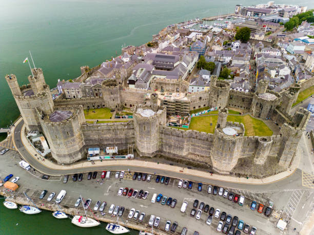 luftaufnahme des alten caernarfon castle in nordwales.  das schloss wird derzeit repariert und wurde für die investitur des prince's of wales genutzt. - caenarvon castle caernarfon castle wales stock-fotos und bilder