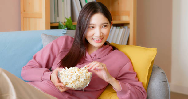 istock woman eat popcorn on couch 1434855931