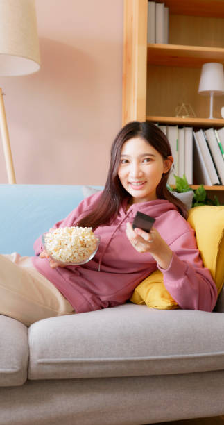istock woman eat popcorn on couch 1434855977