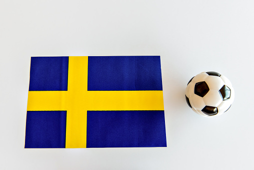 Soccer ball and Swedish flag on white background