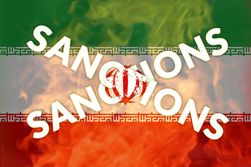 Defocus Iran sanctions concept. Iranian flag, concept on the topic of sanctions in Iran. Words. Fire and flame. Out of focus.