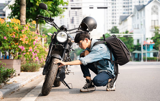 Young Asian man repairing motorbike