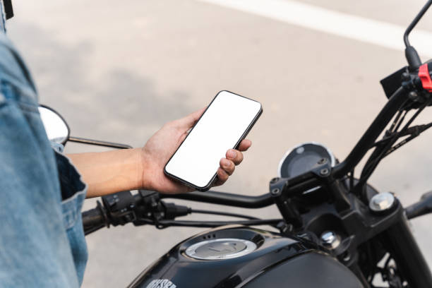 istock image of asian man, sitting on moto using mobile phone 1434878482